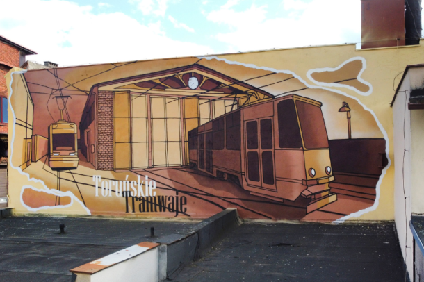 mural przedstawiający zajezdnię tramwajową i tramwaje stary i nowy