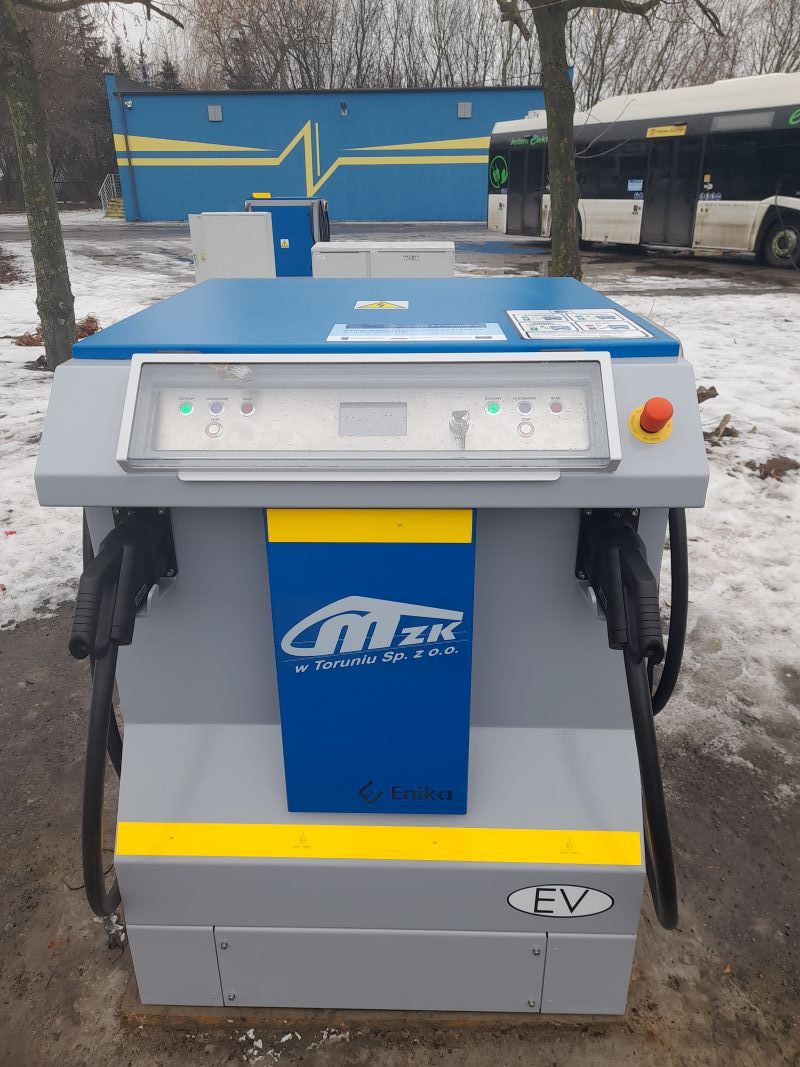 W zajezdni autobusowej przy ul. Legionów w Toruniu trwa montaż ładowarek zakupionych w ramach projektu „Zakup autobusów zeroemisyjnych wraz z dostawą i  integracją infrastruktury do ładowania” współfinansowanego ze środków EFRR w ramach Programu Fundusze Europejskie dla Kujaw i Pomorza. Projekt obejmuje zakup 10 autobusów elektrycznych, z których pięć zostało dostarczonych do Torunia w listopadzie ubiegłego roku, a także dostawę i montaż infrastruktury do ich ładowania. Dzięki środkom unijnym, w ramach projektu, uruchomionych zostanie: •	10 punktów ładowania wolnego o mocy 60 kW każda na terenie zajezdni autobusowej,  •	dwie ładowarki szybkie, pantografowe, o mocy 400 kW każda, zlokalizowane na pętli autobusowej przy ul. Kolankowskiego oraz pętli autobusowo-tramwajowej „Olimpijska”. Obecnie wykonawca - firma Enika sp. z o.o.,  z którym 2 kwietnia 2025 r. zawarta została umowa - zamontował ładowarki na terenie zajezdni autobusowej. Poprawność ładowania sprawdzono na urządzeniu imitującym autobus elektryczny. Ładowarki zostaną uruchomione po przejściu badań Urzędu Dozoru Technicznego. Koszt zakupu ładowarek to ponad 5 mln zł brutto, z czego ok. 2,9 mln zł stanowi dofinansowane ze środków UE. Koszt zakupu autobusów to 31,4 mln zł brutto, przy 17,9 mln zł dofinansowania. #FunduszeEuropejskie #FunduszeUE